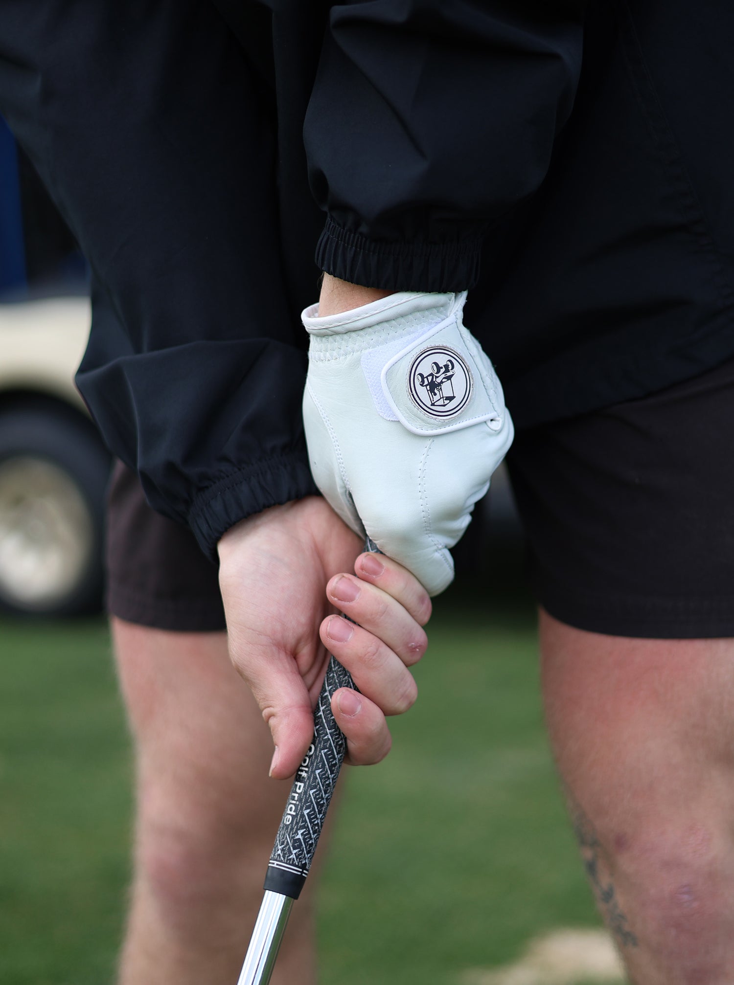 a person holding a golf club with a glove on it.